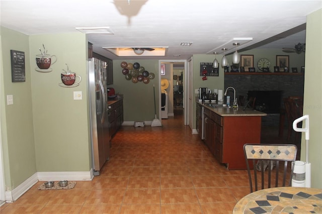 kitchen with visible vents, baseboards, ceiling fan, stainless steel refrigerator with ice dispenser, and a sink