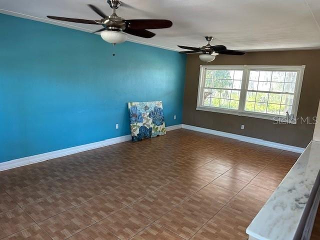 tiled spare room featuring ornamental molding and baseboards