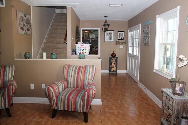 living area with stairs, visible vents, baseboards, and tile patterned floors