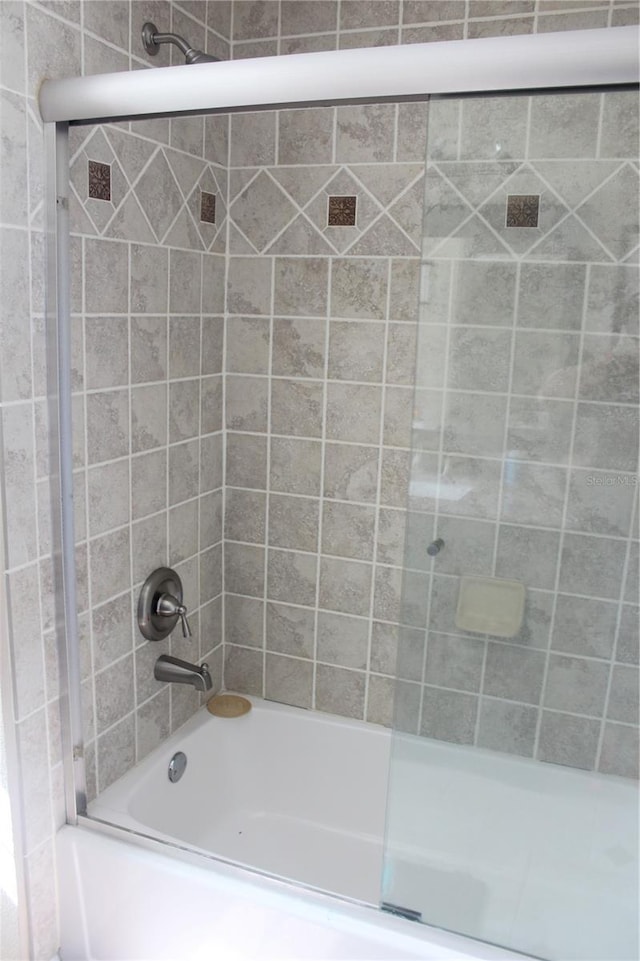 bathroom with shower / bath combination with glass door