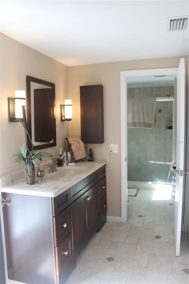 full bath with a stall shower, vanity, visible vents, and baseboards