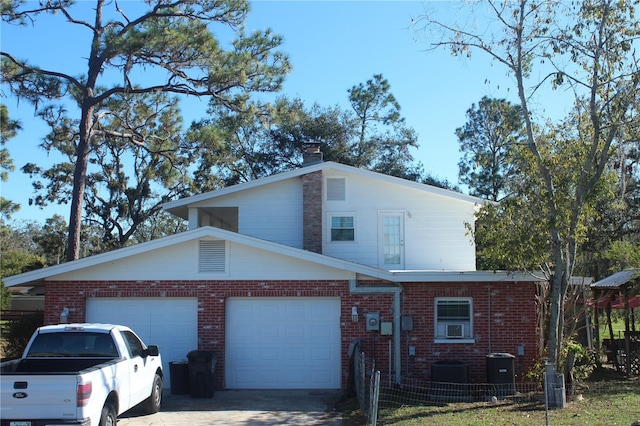 view of front of property with brick siding, fence, driveway, and an attached garage