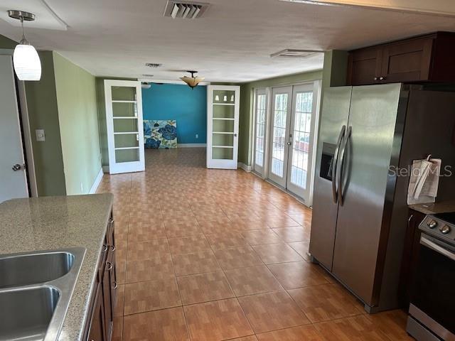 kitchen featuring dark brown cabinetry, visible vents, french doors, appliances with stainless steel finishes, and pendant lighting