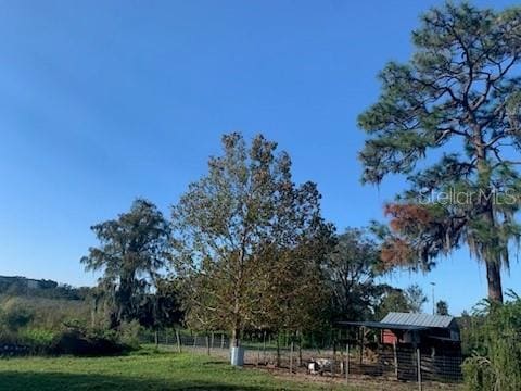 view of yard with fence and a rural view