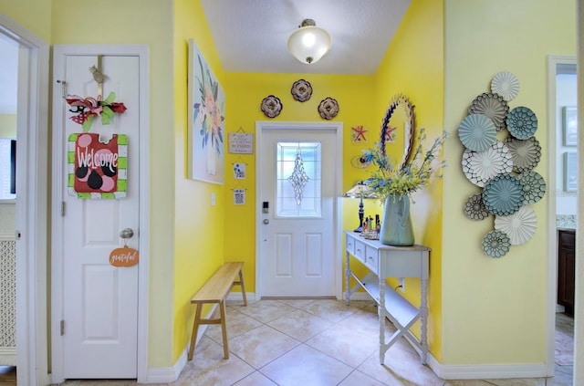 foyer entrance with light tile patterned flooring and a textured ceiling