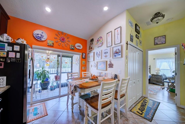 tiled dining space with vaulted ceiling