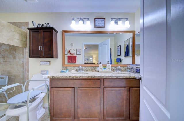 bathroom featuring tiled shower, a textured ceiling, vanity, and toilet