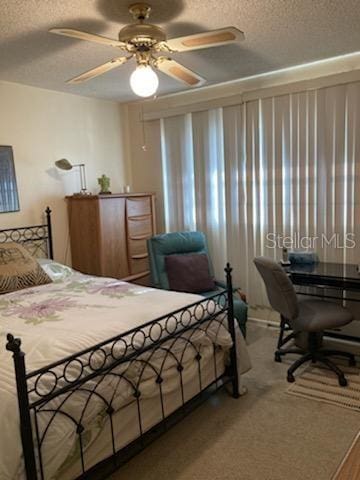 carpeted bedroom with a textured ceiling and ceiling fan