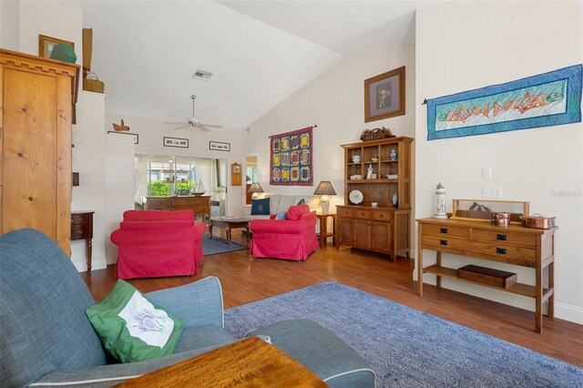 living room with ceiling fan, wood-type flooring, and vaulted ceiling