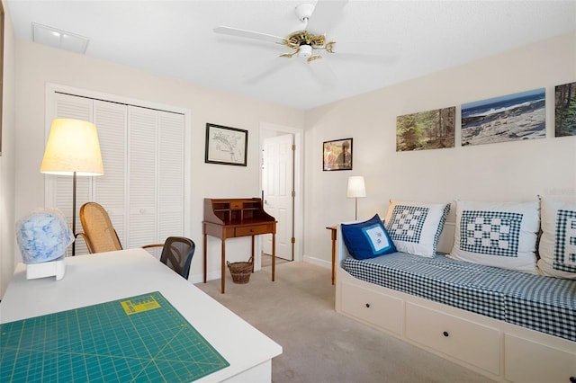 carpeted bedroom with ceiling fan and a closet