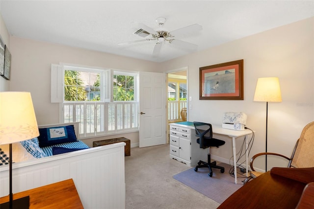 carpeted office space featuring ceiling fan