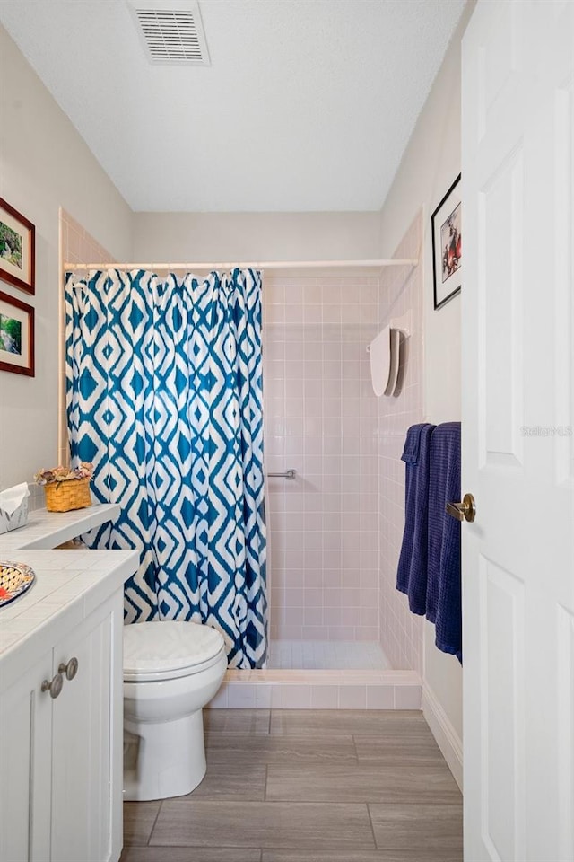 bathroom featuring vanity, a shower with shower curtain, and toilet