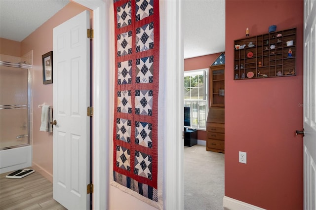 hall featuring hardwood / wood-style floors and a textured ceiling