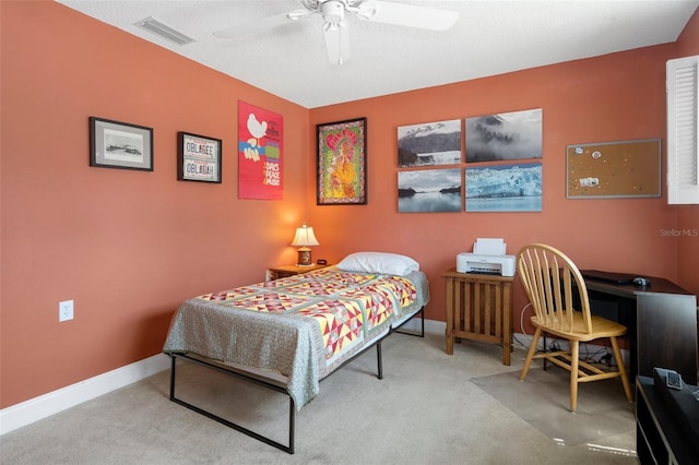 carpeted bedroom with ceiling fan and a textured ceiling