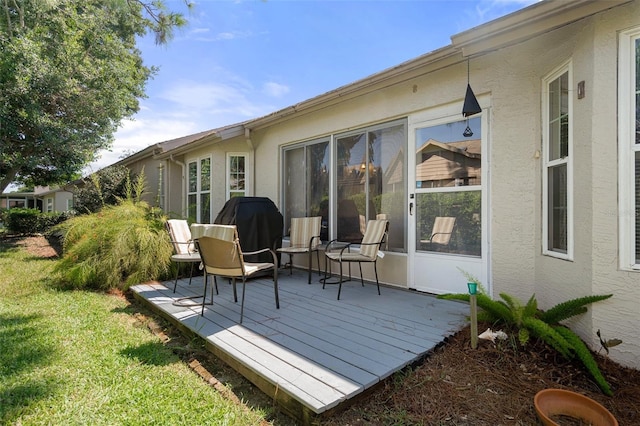 wooden deck with a yard and grilling area