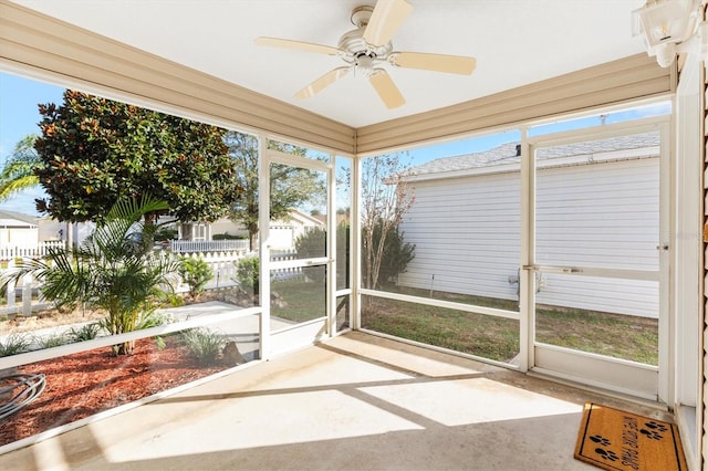 unfurnished sunroom with ceiling fan