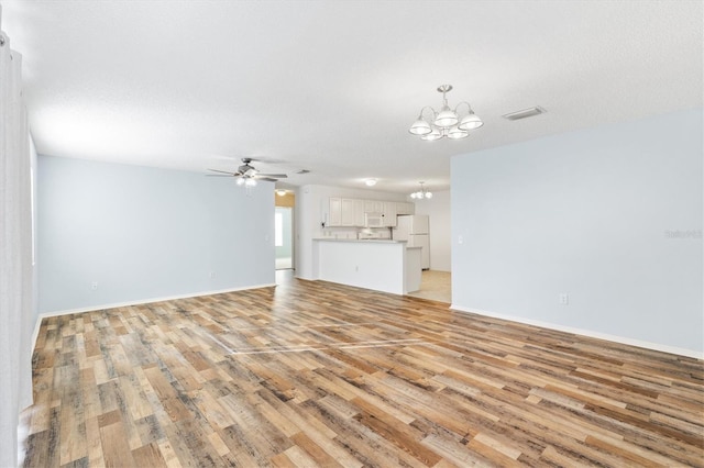 unfurnished living room with a textured ceiling, ceiling fan with notable chandelier, and light hardwood / wood-style floors