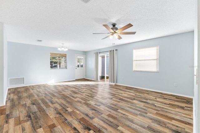 unfurnished room with ceiling fan with notable chandelier, wood-type flooring, and a textured ceiling