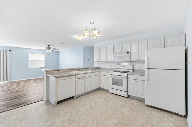 kitchen featuring white appliances, white cabinets, ceiling fan with notable chandelier, light wood-type flooring, and decorative light fixtures