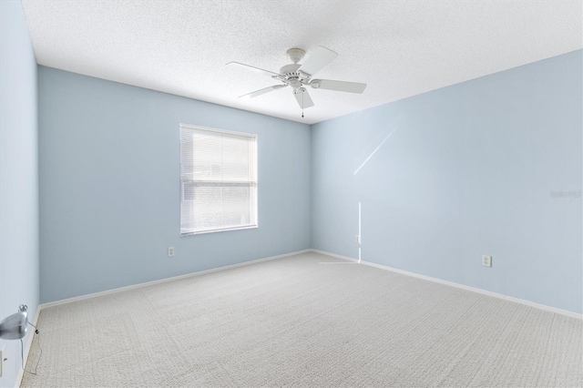 carpeted spare room featuring ceiling fan and a textured ceiling