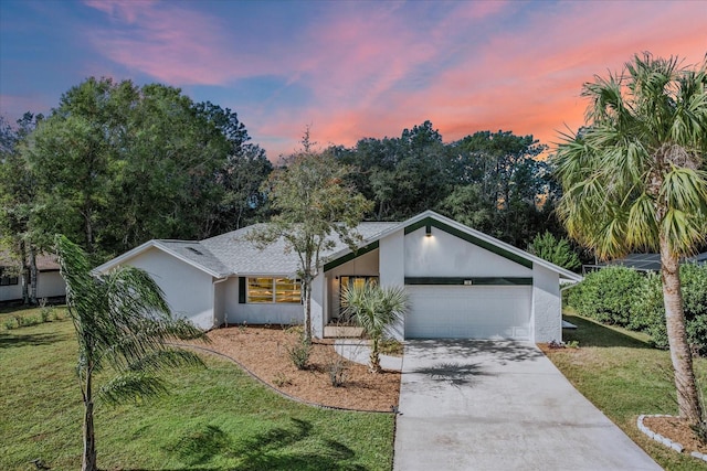 ranch-style house featuring a yard and a garage