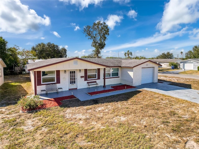 single story home with covered porch, a front yard, and a garage