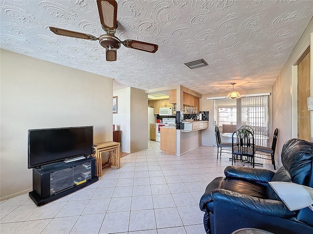 tiled living room featuring ceiling fan and a textured ceiling