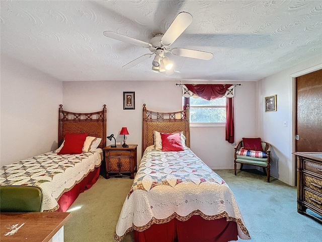 bedroom featuring light carpet, a textured ceiling, and ceiling fan