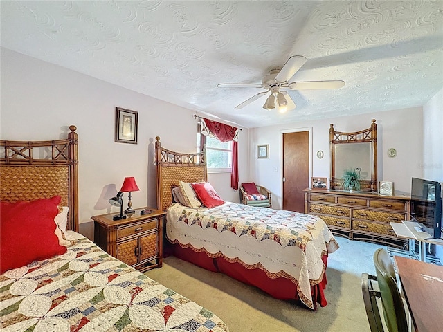 carpeted bedroom featuring ceiling fan and a textured ceiling