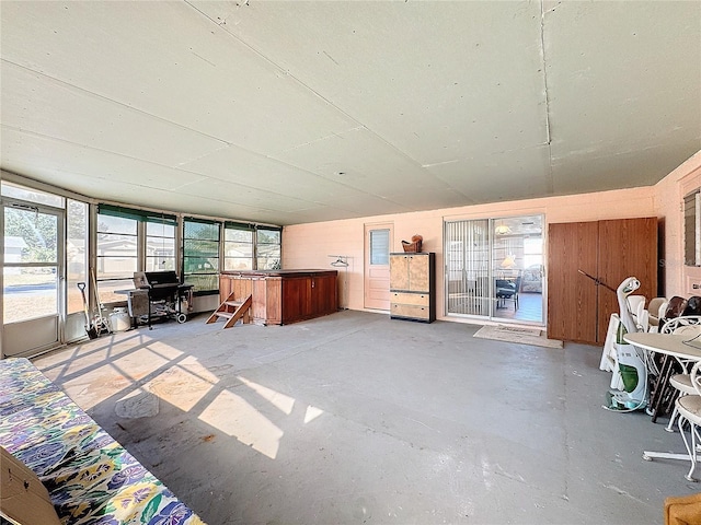 unfurnished living room with wood walls and concrete flooring