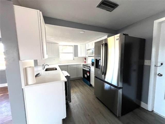 kitchen with dark hardwood / wood-style flooring, white cabinetry, sink, and appliances with stainless steel finishes