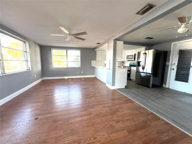 unfurnished living room with ceiling fan and dark wood-type flooring