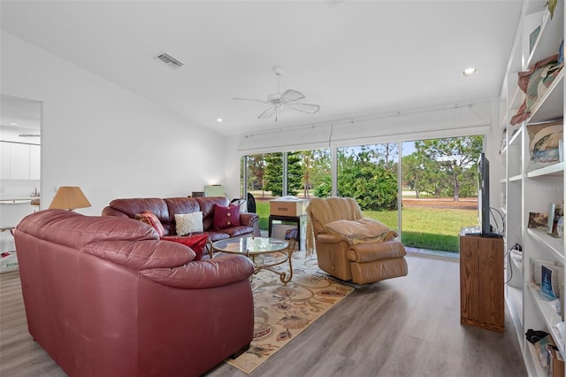 living room featuring light wood-type flooring, vaulted ceiling, and ceiling fan