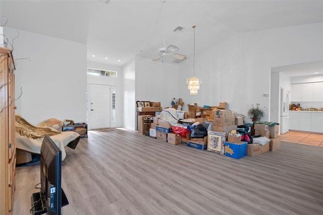 living room with light wood-type flooring, high vaulted ceiling, and ceiling fan