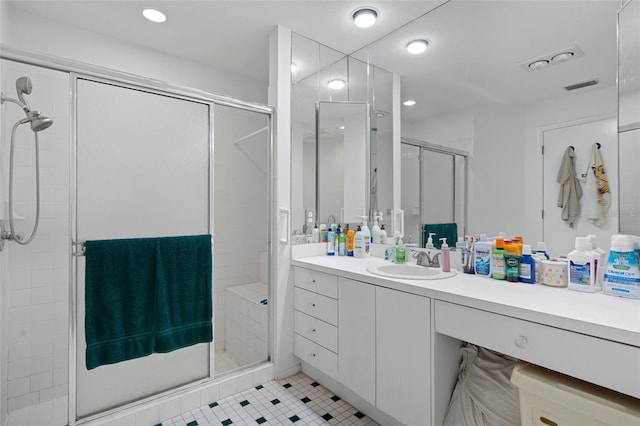 bathroom featuring tile patterned flooring, a shower with shower door, and vanity