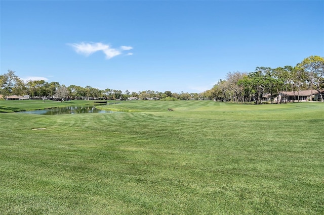 surrounding community featuring a lawn and a water view