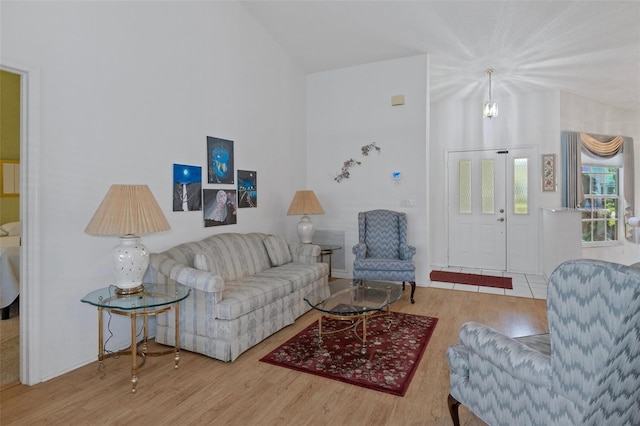 living room featuring hardwood / wood-style floors, a chandelier, and lofted ceiling