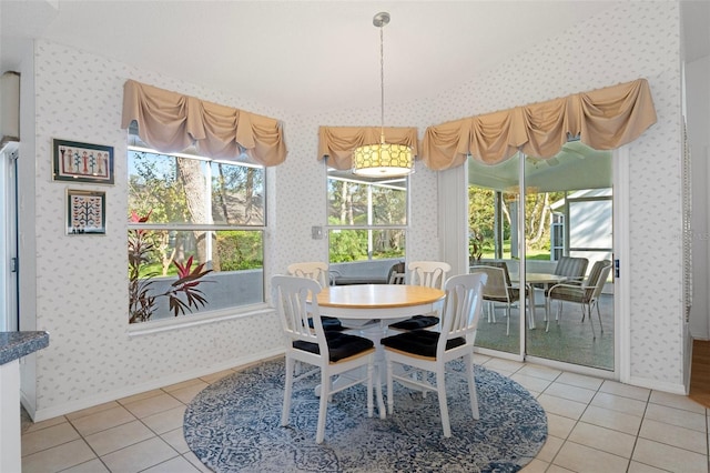 tiled dining space featuring vaulted ceiling