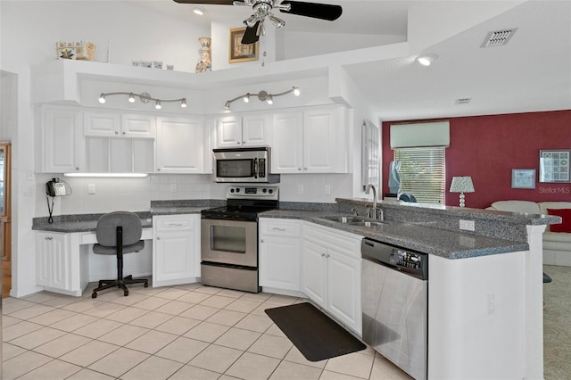 kitchen with white cabinetry, sink, kitchen peninsula, lofted ceiling, and appliances with stainless steel finishes