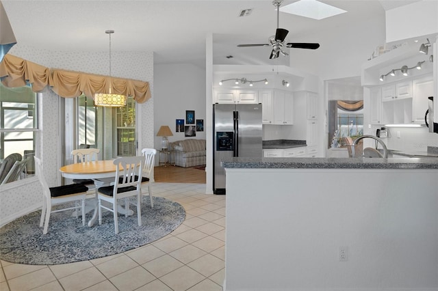 kitchen with ceiling fan, light tile patterned floors, kitchen peninsula, white cabinets, and appliances with stainless steel finishes