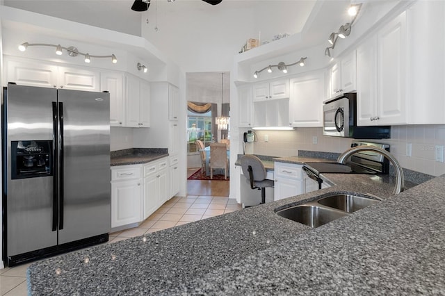 kitchen with white cabinets, light tile patterned floors, and stainless steel appliances