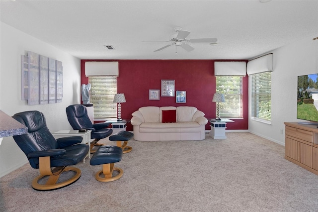 carpeted living room with ceiling fan and a textured ceiling