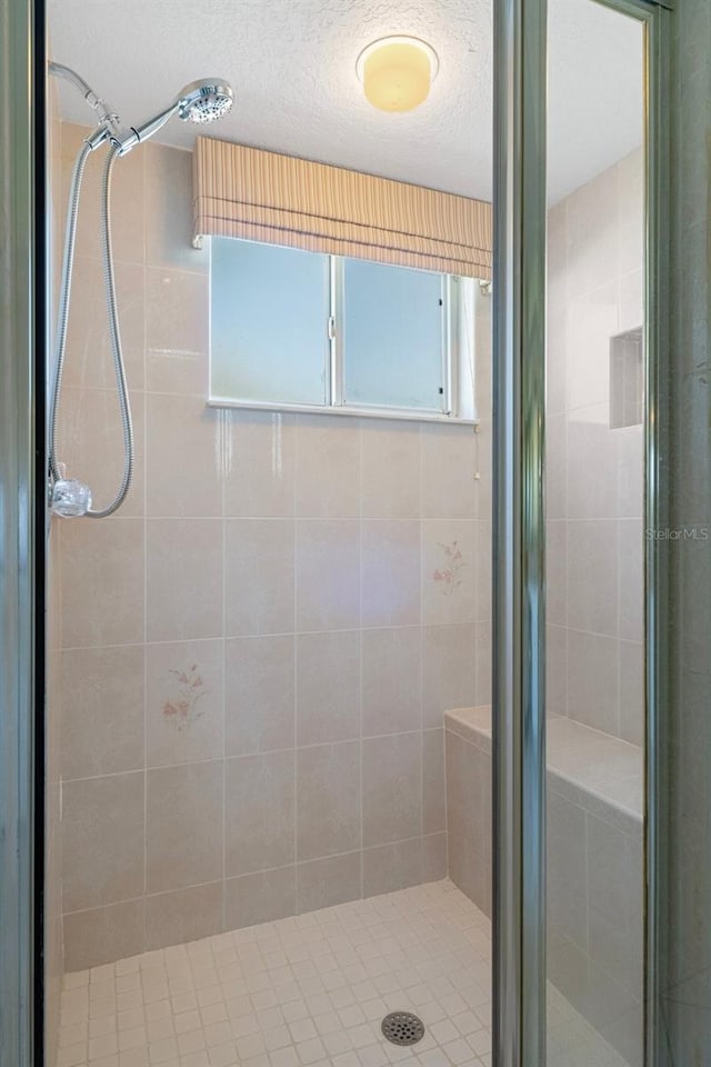 bathroom with a textured ceiling and walk in shower