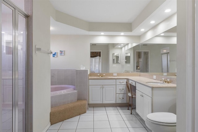 bathroom featuring tile patterned flooring, vanity, tiled bath, and toilet