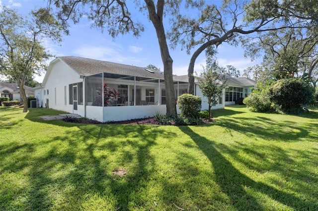 back of house featuring a lanai and a lawn