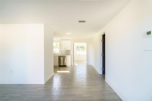 corridor with a textured ceiling and sink