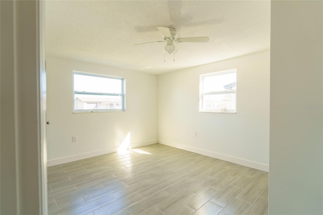 unfurnished room featuring ceiling fan, plenty of natural light, a textured ceiling, and light wood-type flooring