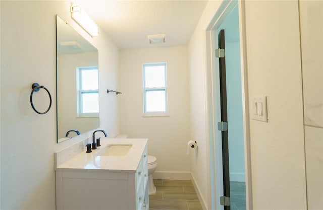 bathroom with vanity, wood-type flooring, and toilet