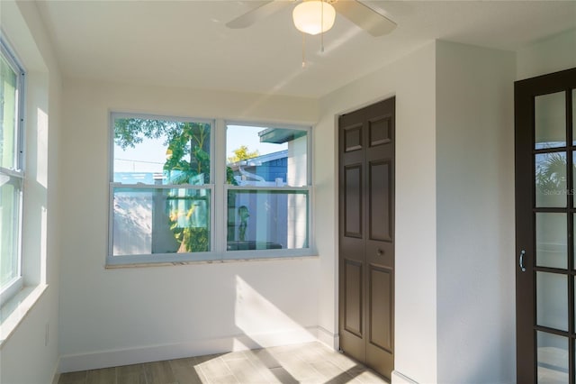 unfurnished sunroom featuring ceiling fan