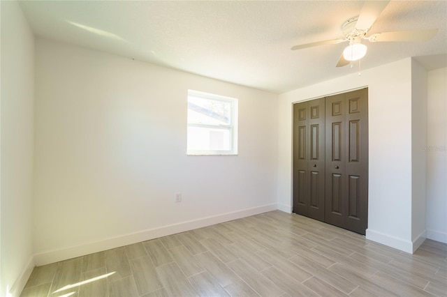 unfurnished bedroom featuring a textured ceiling, light hardwood / wood-style flooring, a closet, and ceiling fan